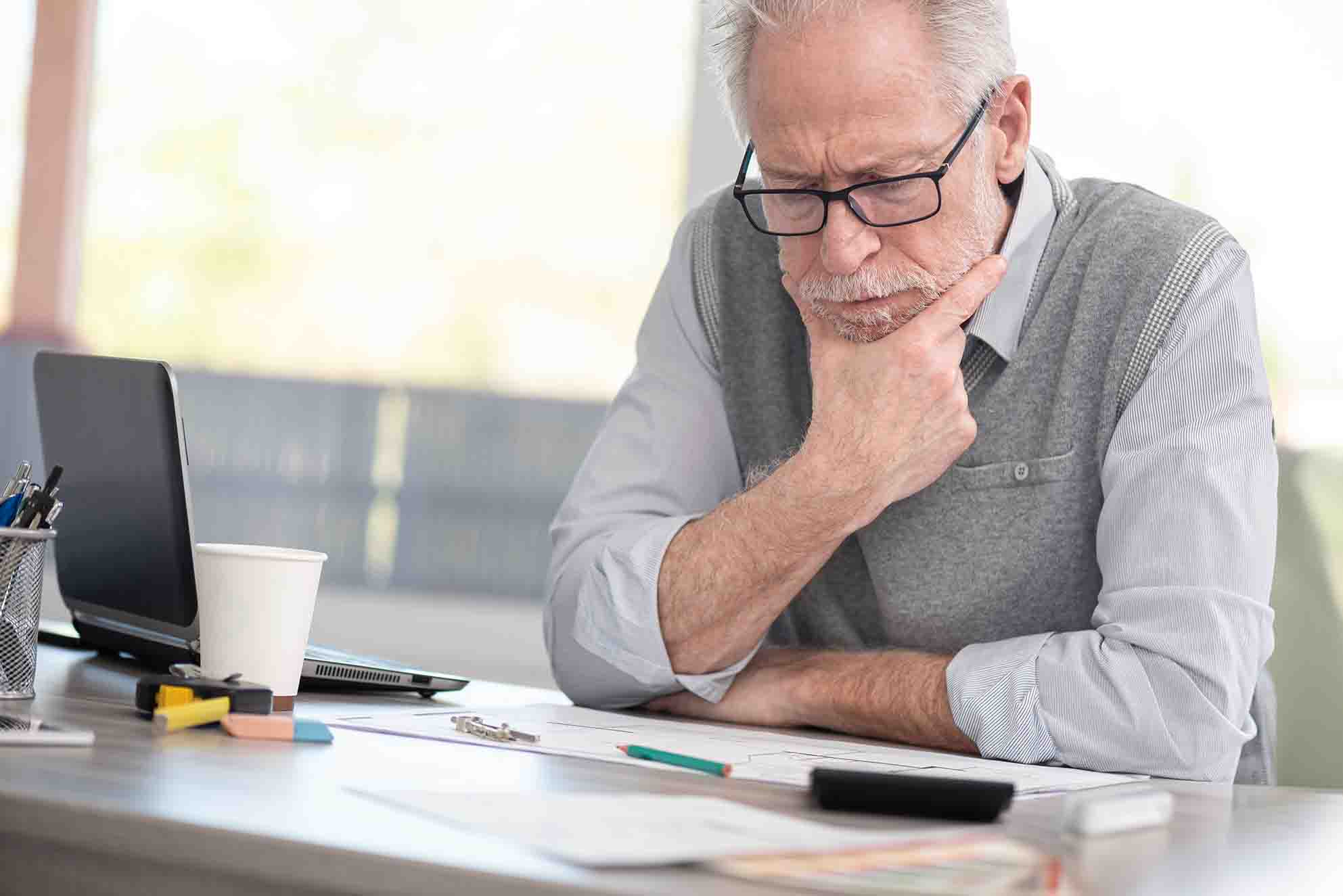 Decision Making Skills for Leaders - Man in workplace deep in thought, thinking about making a decision at work